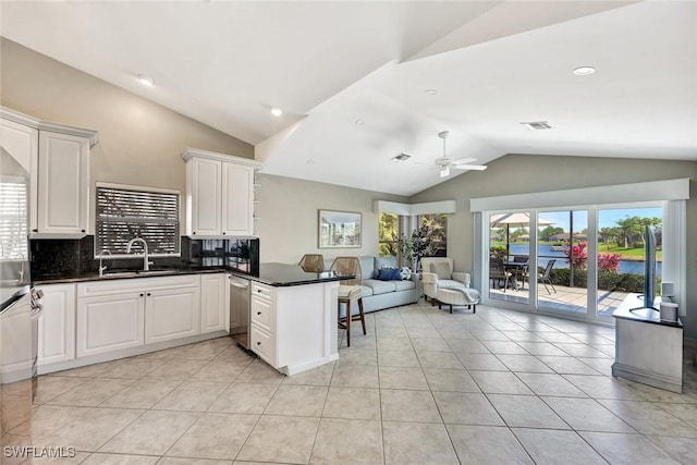 kitchen with lofted ceiling, a peninsula, a sink, visible vents, and open floor plan