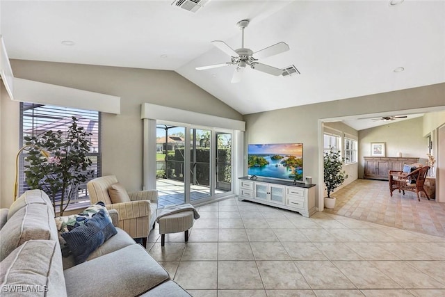 living area featuring light tile patterned floors, vaulted ceiling, visible vents, and a healthy amount of sunlight