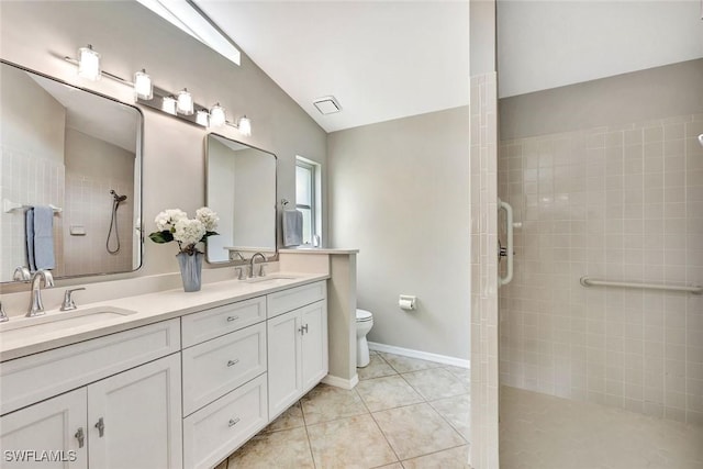 full bath featuring toilet, tile patterned flooring, a sink, and tiled shower