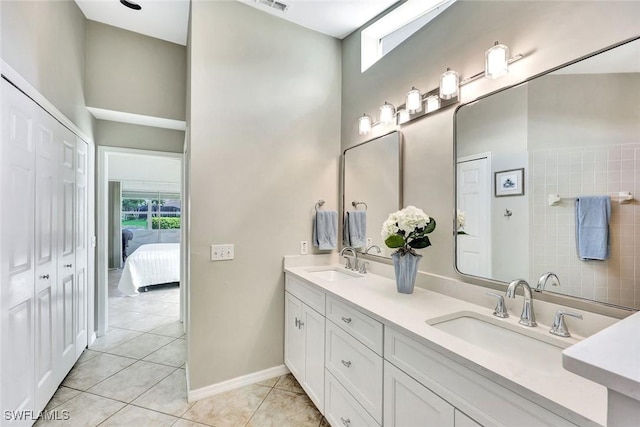 bathroom with tile patterned flooring, a sink, and a healthy amount of sunlight