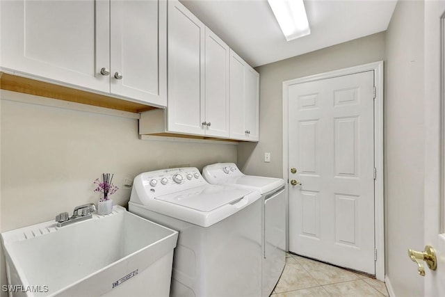 laundry area featuring light tile patterned floors, independent washer and dryer, a sink, and cabinet space