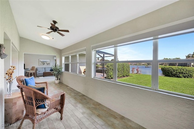 sunroom with a water view, a ceiling fan, and lofted ceiling