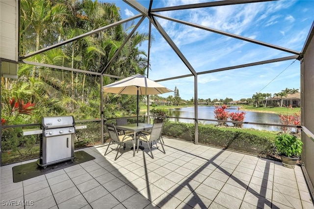 view of patio / terrace featuring outdoor dining space, a lanai, a water view, and grilling area