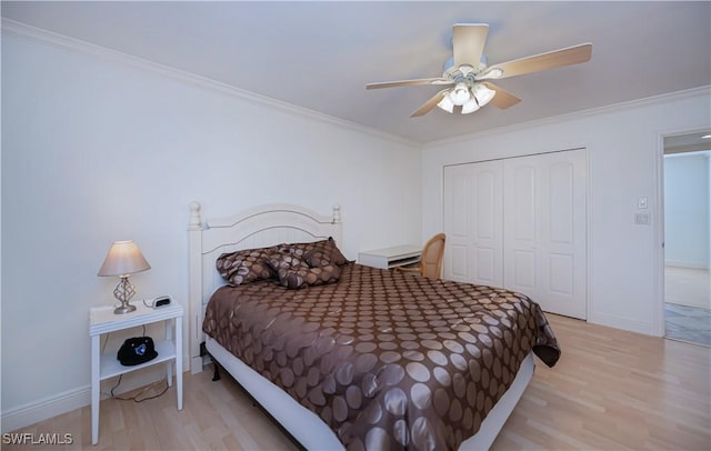 bedroom featuring light wood-style flooring, a closet, ornamental molding, a ceiling fan, and baseboards