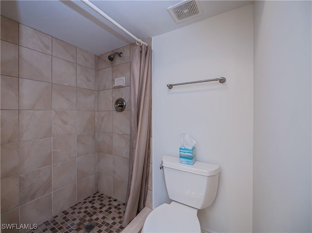 bathroom featuring a shower stall and toilet
