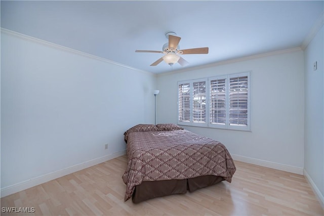 bedroom featuring wood finished floors, ornamental molding, baseboards, and a ceiling fan
