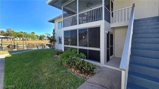 view of side of property with a yard, stucco siding, and a water view