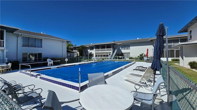 community pool featuring fence and a patio area