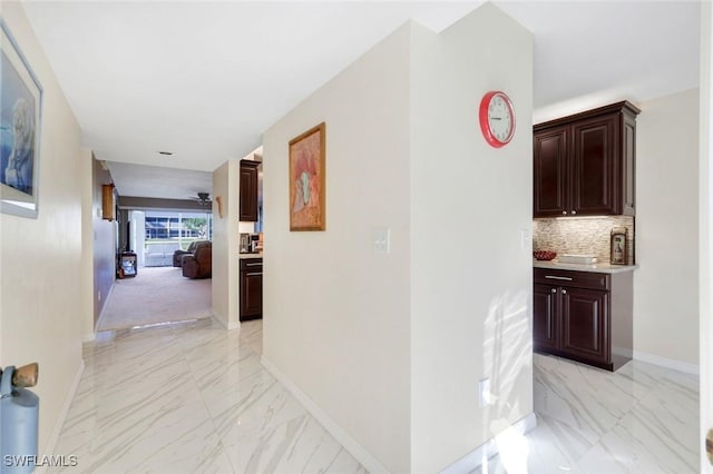 corridor with marble finish floor and baseboards