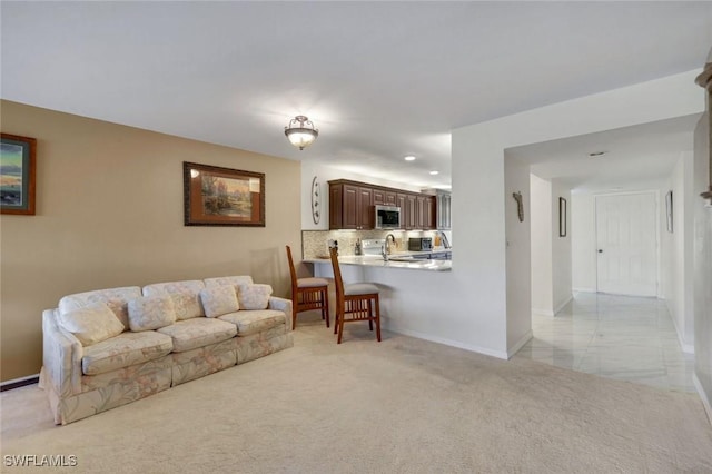 living room featuring light colored carpet and baseboards