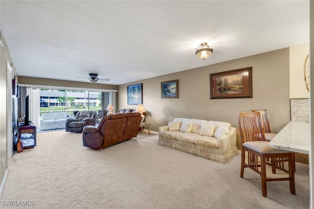 carpeted living room featuring ceiling fan and baseboards