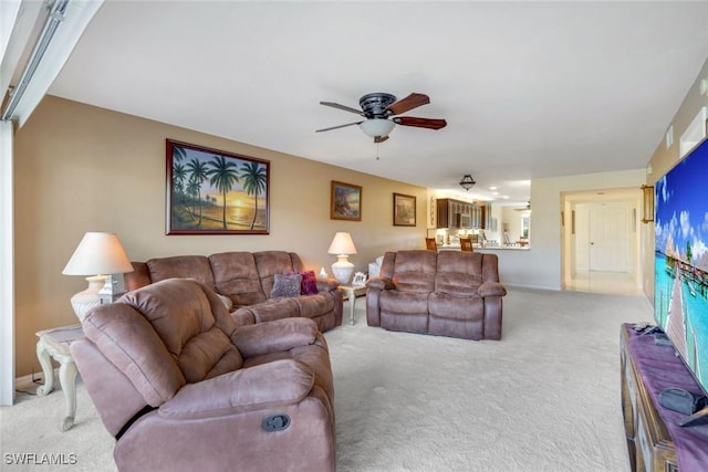 living area with light carpet and ceiling fan