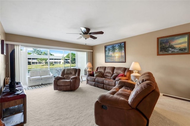 living area with a ceiling fan and carpet flooring