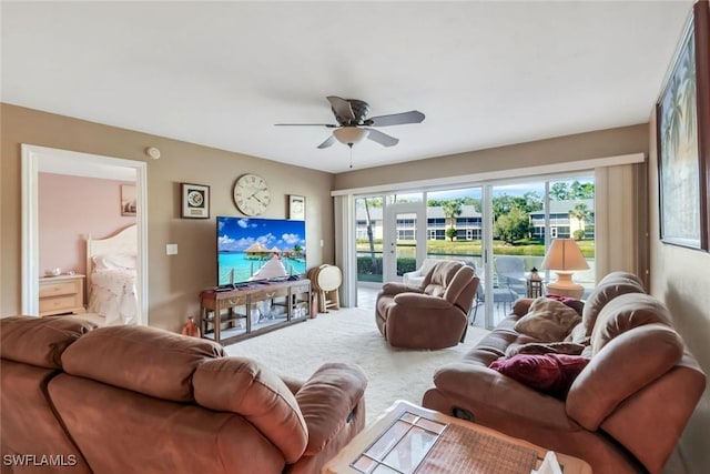 living area with ceiling fan, a wealth of natural light, and french doors