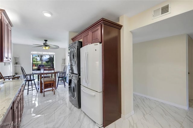 laundry area featuring a ceiling fan, visible vents, baseboards, marble finish floor, and stacked washing maching and dryer