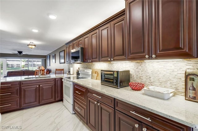 kitchen with electric range, a sink, marble finish floor, backsplash, and stainless steel microwave