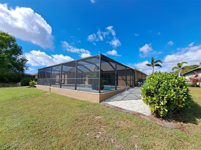 back of property featuring an outdoor pool, glass enclosure, and a lawn