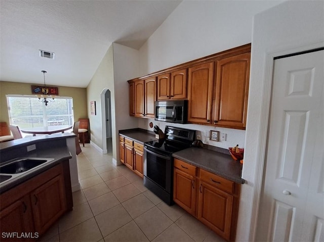 kitchen with visible vents, arched walkways, dark countertops, stainless steel microwave, and black / electric stove