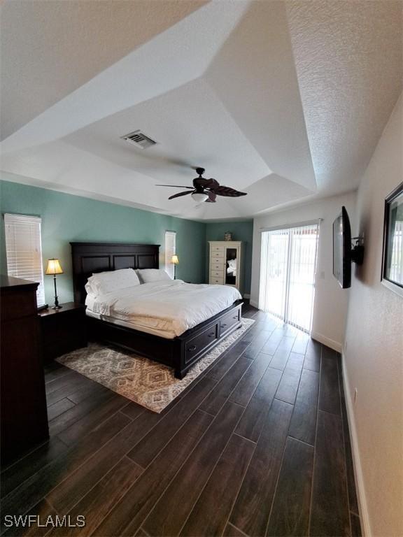 bedroom featuring visible vents, baseboards, ceiling fan, wood tiled floor, and access to outside