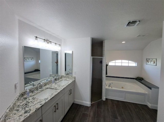 bathroom with visible vents, a tub with jets, wood finish floors, a shower stall, and a sink