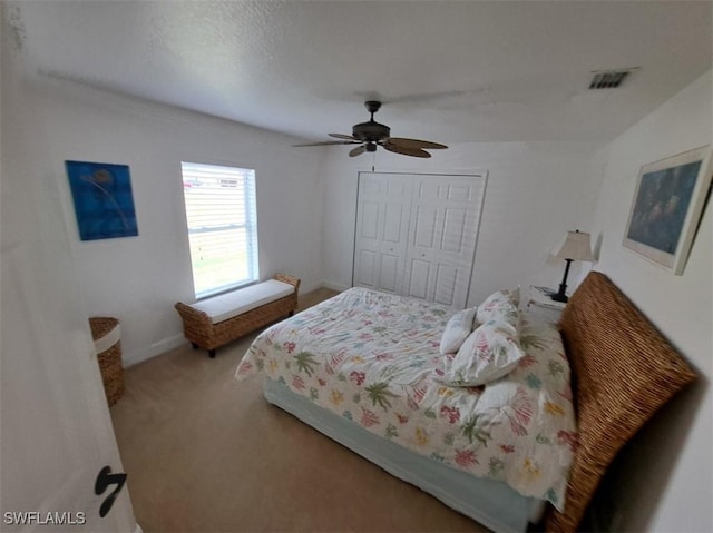 carpeted bedroom with ceiling fan, a closet, visible vents, and baseboards