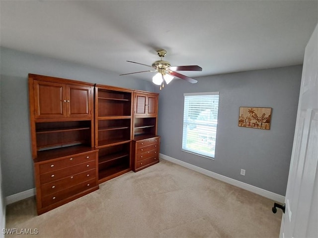 unfurnished bedroom with ceiling fan, light colored carpet, and baseboards