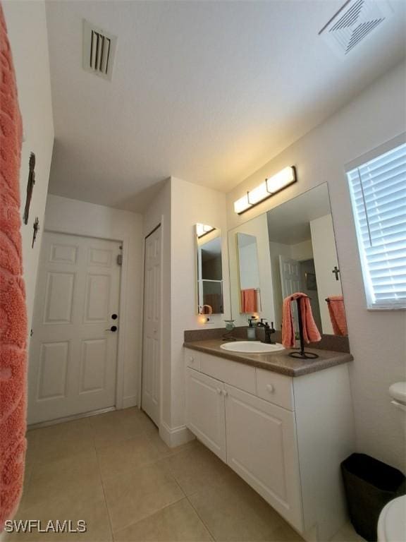 bathroom featuring toilet, vanity, visible vents, and tile patterned floors