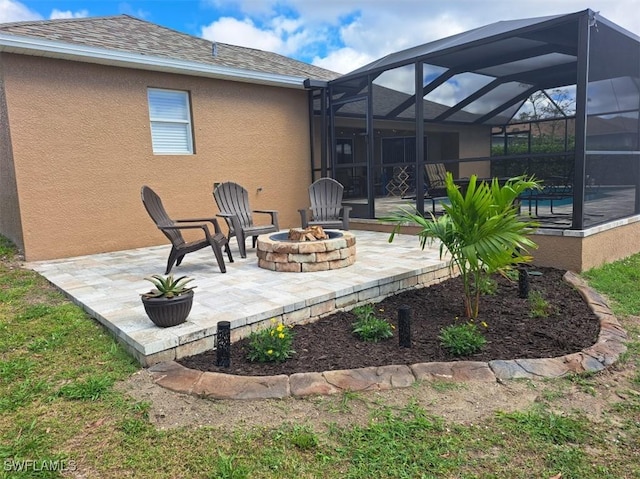 view of patio / terrace featuring a pool, an outdoor fire pit, and glass enclosure