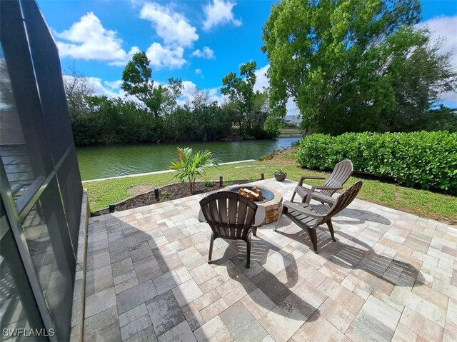 view of patio / terrace with an outdoor fire pit and a water view