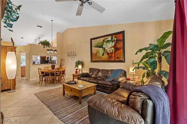 tiled living area with a ceiling fan, vaulted ceiling, and baseboards