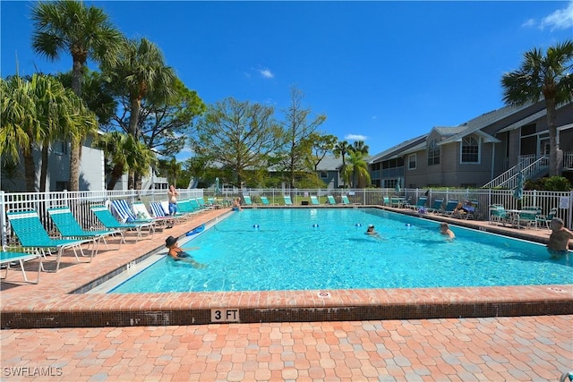 pool with a patio and fence