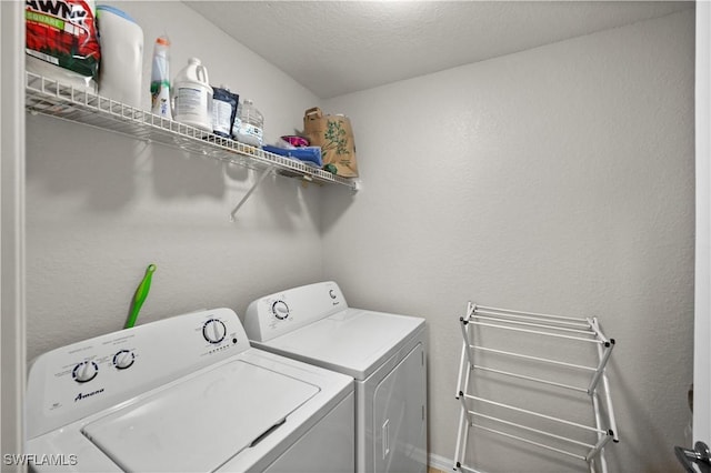 laundry room with laundry area, washing machine and dryer, and a textured ceiling