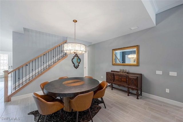 dining space featuring an inviting chandelier, stairs, baseboards, and light wood-style floors