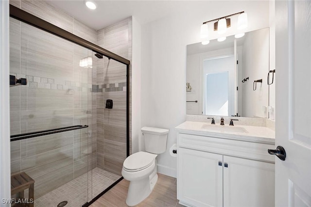 bathroom with a stall shower, vanity, and toilet