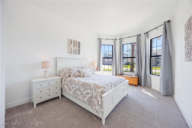 bedroom featuring light carpet and baseboards