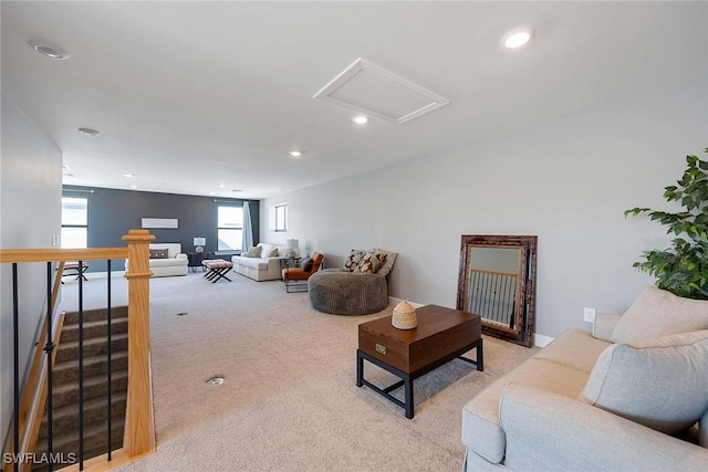 living area featuring recessed lighting, attic access, and light colored carpet