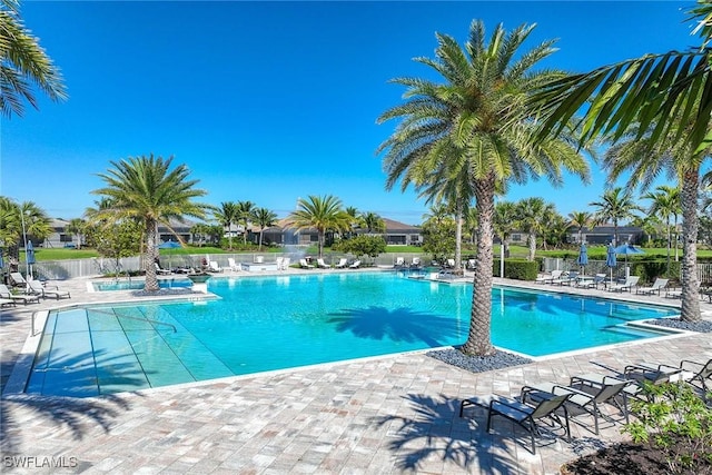 community pool featuring fence and a patio