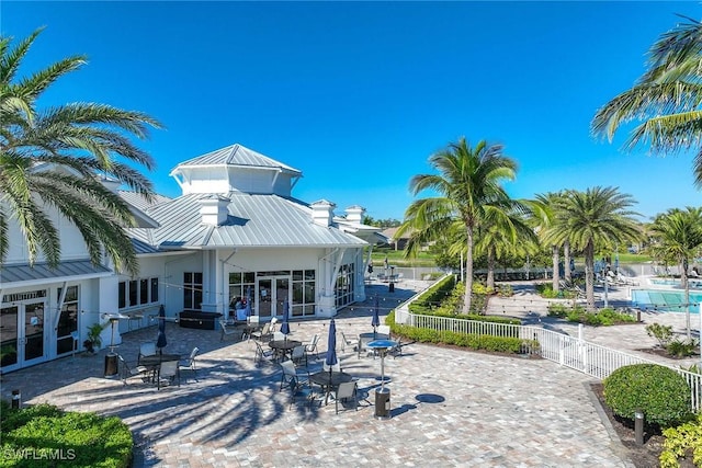 9551 Curlew Dr, Naples, FL 34120 - rear view of house with a standing seam roof, french doors, metal roof, a patio area, and stucco siding