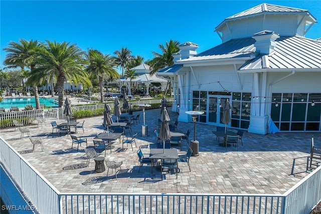 view of patio / terrace with a community pool and fence