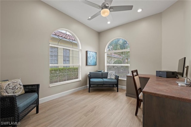 home office featuring plenty of natural light, ceiling fan, light wood-type flooring, and baseboards