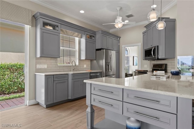 kitchen with visible vents, ornamental molding, stainless steel appliances, gray cabinetry, and light wood-style floors