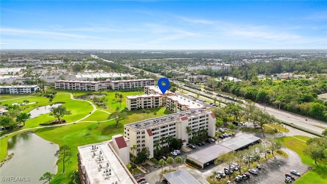 drone / aerial view featuring golf course view and a water view