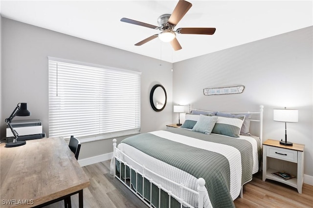 bedroom featuring light wood-style floors, baseboards, and a ceiling fan