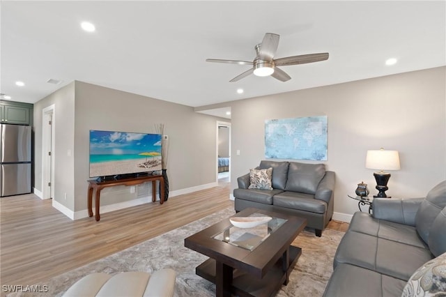 living area featuring light wood-type flooring, baseboards, and recessed lighting