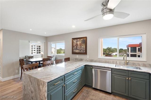 kitchen with dishwasher, a peninsula, light stone countertops, light wood-style floors, and a sink