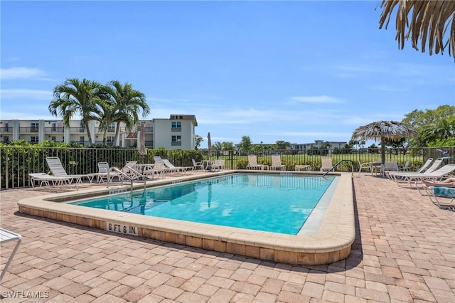 pool with a patio and fence