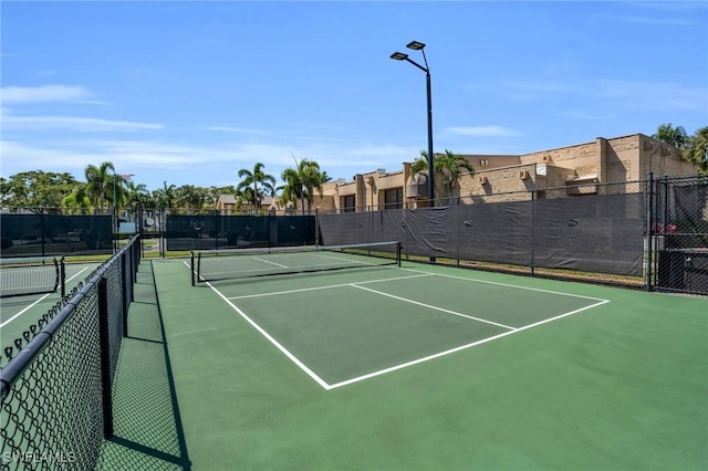 view of tennis court featuring fence