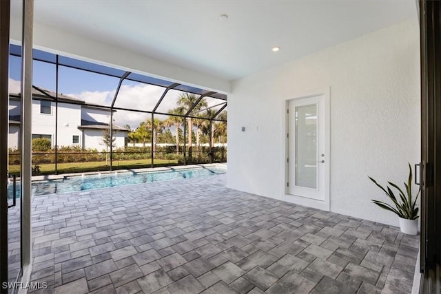 pool featuring glass enclosure and a patio