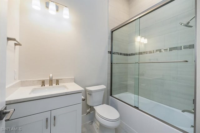 bathroom featuring enclosed tub / shower combo, vanity, and toilet