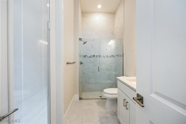 bathroom featuring marble finish floor, toilet, a stall shower, vanity, and baseboards